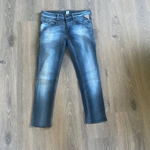 Replay skinny jeans i blå denim - Säljer ett par snygga Replay jeans i blå tvättad denim Klassisk femficksmodell med Replay-logga vid fickan och diskreta slitningar. Jeansen har låg midja och är tillverkade i stretchigt jeansmaterial för en bekväm känsla. Krympte tyvärr tvätten och är därmed i storlek 140 ungefär, vill du ha mått är de bara att höra av sig!