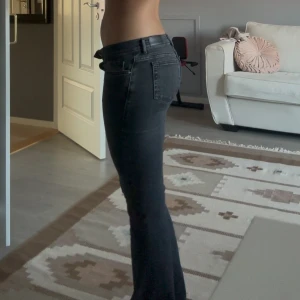 Gråsvarta lågmidjade utsvängda jeans  - Säljer dessa snygga gråsvarta lågmidjade jeansen då de har blivit för små för mig. Har knappast använts och är i väldigt bra skick. Jag är 172 lång och de är pytte lite korta vid hålen för min stil så skulle säga att de skulle passat någon som är lite kortare❤️