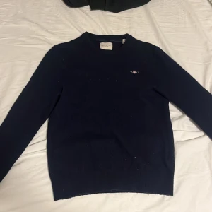 Gant tröja - Säljer denna mörkblåa merinoull gant tröjan då den inte passar mig längre. den är knappt andvänd. Storleken på tröjan är 164 men den är passar mer för nån som har xs. Nypris: ca 1200. Priset är ej hugget i sten