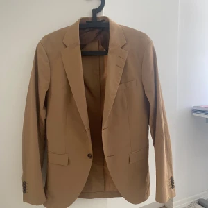 Tiger of Sweden kostym - Säljer denna tiger of Sweden kostym i brun/beige. Endast andvänd en gång och i nyskick.perfekt nu iför hösten eller våren. Nypris är ca. 5000. Både kavaj och byxor ingår men du kan köpa separat, isåfall skriv till mig. Storlek i byxor är 46. Skriv för fler bilder! Vid snabb affär kan jag sänka pris.