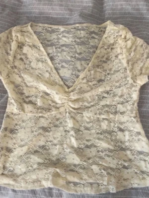 Beige spetsblus - Säljer en beige, kortärmad blus i spets.