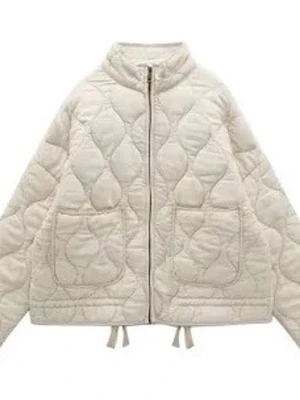 Beige quiltad pufferjacka - Stilren beige pufferjacka med quiltat mönster och två stora framfickor. Jackan har dragkedja framtill, croppad passform och rundad krage. Perfekt för dig som vill ha en trendig och bekväm jacka till vardags.