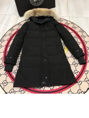 Svart dunjacka med pälskrage - Snygg svart dunjacka från Canada Goose med lång passform och huva med lyxig pälskant. Jackan har knappar och dragkedja framtill samt ribbade muddar vid ärmsluten. Perfekt för kalla vinterdagar och riktigt varm.