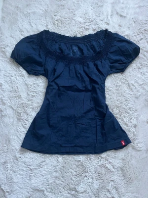 Mörkblå vintage blus  - Snygg mörkblå blus med puffärmar och bred, smockad ringning. Toppen har en feminin siluett och är tillverkad i mjukt bomullstyg. Perfekt för dig som gillar en enkel men trendig look🦢🤍