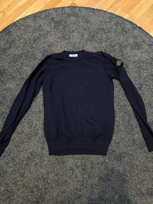 Mörkblå stickad tröja Stone Island - Säljer min brorsas gamla Mörkblå stickad tröja från Stone Island Junior. Tröjan är 100% ull och i mycket bra skick. Från början var den 170 men har krympt lite i tvätten