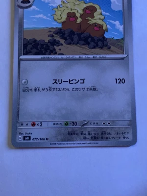 Alolan Dugtrio Pokémonkort SV8 - Japanskt Pokémonkort med Alolan Dugtrio från Scarlet & Violet SV8. Kortet har en bild på tre bruna Diglett med blont hår, står på en jordhög med blå himmel i bakgrunden. Kortnummer 077/106 U. Perfekt för samlare eller Pokémonfans.