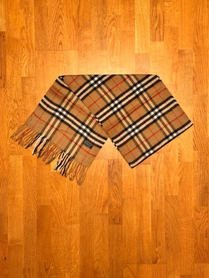Beige Burberry halsduk - Säljer en beige halsduk från Burberry. Halsduken är i gott skick och är gjord i 100% kashmir. Var inte rädd för några frågor. Pris diskuteras inte!