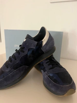 Philippe Model Trainers - Sjukt Feta Philippe Model Trainers. Fin mörkblå färg med unikt militärmönster. Användning syns lite på undersidan å några små tecken på själva skon men inga hål eller liknande. Box Tilkommer!