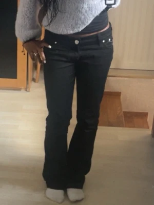 Svarta boocut Jens Victoria beckham - Säljer ett par svarta jeans med utsvängda ben och synliga knappar framtill. Storlek 27/35 jag är 162 och dom passar perfekt i längden. Man kan säga att det är storlek xs/s. Lite slitna nertrampade längst ner (se bild 5) men syns inte när man har på sig dom. PRISET GÅR ATT DISKUTERA!!!