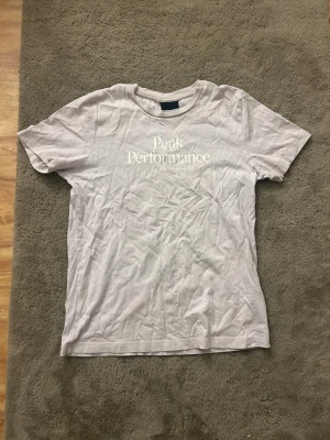  Peak Performance t-shirt - Snygg ljus-rosa  t-shirt från Peak Performance med klassisk logga tryckt framtill. T-shirten har rund halsringning och korta ärmar. Tillverkad i mjuk bomull för en skön känsla hela dagen.