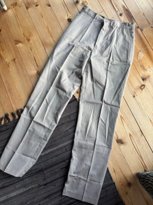 🤍 Stilrena ljusgrå kostymbyxor – tidlös & lättmatchad - Snygga beige chinos med raka ben och klassisk passform. Byxorna har diskreta sidofickor och stängs med knapp och dragkedja. Perfekta för en clean och stilren look. Tillverkade i mjukt bomullsmaterial som känns skönt mot huden.                                         Är du intresserad, kan jag skicka måtten