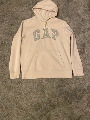 GAP - Grå och vit GAP hoodie. Skön och varm hoodie med snören för luvan.