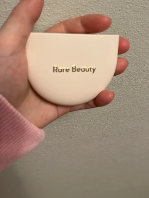 Rare Beauty bronzer - Bronzer från Rare Beauty i nyansen Natural. Kommer i en halvmåneformad, ljusbeige plastförpackning.  Endast testad