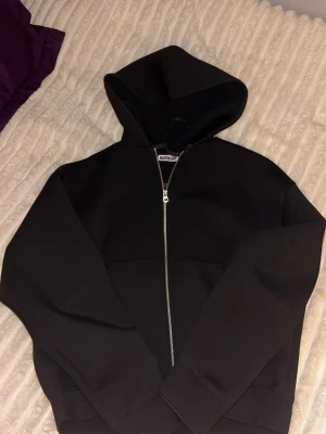 Weekday - Scuba Zip Hoodie - Uppgradera din garderob med en stilren och trendig scuba zip hoodie — perfekt för både vardags- och streetwear-looks! Scuba-materialet ger en mjuk, lite tjockare känsla som sitter snyggt och håller dig varm utan att bli klumpig, samtidigt som den har en modern silhuett och bra form.    Använd väldigt få gånger och skick är precis som ny!