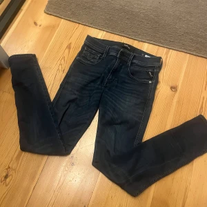 Replay jeans - 28W, 30L, Snygga mörkblå slim fit jeans från replay med klassiska fem fickor och subtila sömdetaljer på bakfickorna. Jeansen har en modern passform och är tillverkade i stretchig denim för extra komfort. 