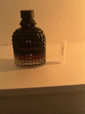 Valentino parfym born in Roma intense  - Säljer en parfym från Valentino i en cool, mörk flaska med nitar och svart lock. Flaskan har en snygg gradient från svart till transparent och känns riktigt lyxig. Perfekt för dig som gillar exklusiva dofter och snygg design.