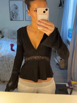 Svart topp med spetsdetalj från Gina Tricot – storlek XS - Svart långärmad topp från Gina Tricot i storlek XS. Sparsamt använd och i fint skick. Säljer eftersom den knappt används. 