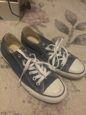 Blå Converse sneakers med vita detaljer - Klassiska blå Converse sneakers med vita snören. Använda en gång💞