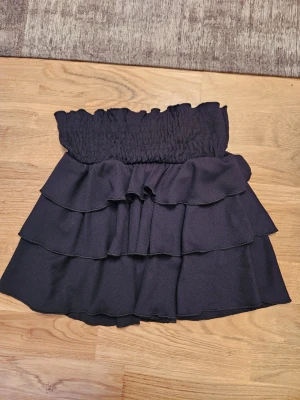 Svart volangkjol från RYVLS - Fin svart kjol från RYVLS. Bred skön resår i midjan. Oanvänd