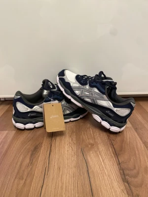 ASICS sneakers -  Aldrig använda, lappar kvar. Fräscha Asics i vitt, beige och navy blue – perfekt både till vardags och träning.   📏 Storlek: 45  💰 Pris: 1299kr  📦 Skick: Helt nya, med tag  🚚 skickas inom 1-2 dagar