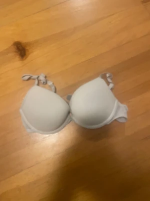 Vit push-up bh från H&M 70A - Säljer en vit push-up bh från H&M i storlek 70A. Bh:n har släta kupor och justerbara axelband med knyt. Materialet är mjukt och stretchigt med polyamid och elastan för skön passform. Perfekt under toppar och klänningar.