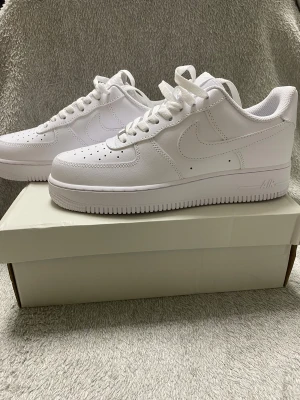 Nya Airforces - Vita, Stl 42 - Säljer ett par helt nya, oanvända Nike Air Force 1 i klassisk vit färg, storlek 42. Ikoniska och stilrena sneakers som passar alla outfits – perfekta för både vardag och fest.  Detaljer: 	•	Modell: Nike Air Force 1 	•	Färg: Vit 	•	Storlek: 42 	•	Skick: Helt nya, aldrig använda 	•	Tillbehör: Originalkartong   Ett av de mest populära skomodellerna från Nike och ofta slutsålda. Bekväma, grym passform och tidlös design. Säljer billigt eftersom det är snart julafton och alla behöver köpa presenter.