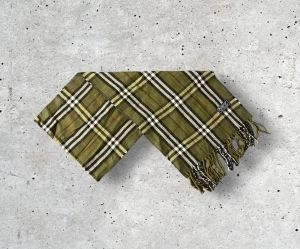 Mörkgrön Burberry Scarf - ✨ Klassisk Burberry-halsduk i 100% ull – elegant mörkgrön ✨ Säljer en tidlös Burberry-halsduk i en djup, mörkgrön färg med det ikoniska rutmönstret. Tillverkad i 100% mjuk och värmande ull som känns lyxig, håller formen väl och ger en exklusiv helhetskänsla. En perfekt accessoar som ger en subtil men sofistikerad färgton till både vardags- och kvällsoutfits. 🧵 Skick: Mycket fint skick, varsamt använd 🌟 Känsla: Mjuk, varm och följsam 📦 Frakt: Skickas tryggt inom 24h 📏 Mått: Längd-145cm, Bredd30cm