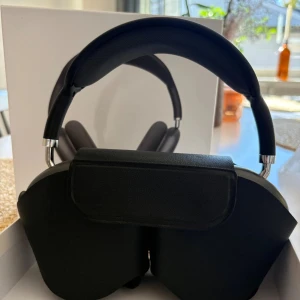 AirPods Max - Snygga Apple AirPods Max i Space Gray, over-ear trådlösa hörlurar med aktiv brusreducering. Komplett med originalförpackning och skyddsfodral. Hörlurarna ser ut att vara i mycket gott skick utan synligt slitage eller repor. Perfekt för musik, film och samtal.
