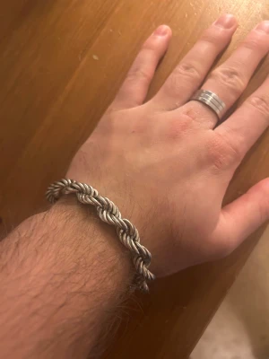 10 mm Cordell kedja äkta silver 925 - Snyggt och robust armband i silverfärgat metall med tvinnad design. Låset är klassiskt och smidigt att använda. Perfekt för dig som gillar chunky smycken med lite edge och vill sticka ut med en cool detalj på handleden.