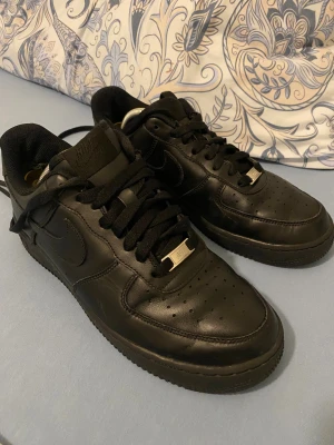 Svarta Nike Air Force 1 sneakers - Säljer ett par klassiska helsvarta Nike Air Force 1 sneakers. Låda finns till skorna. Priset är inte hugget i sten.