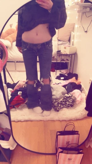 Mörkblå bootcut jeans med slitna knän - Säljer ett par mörkblå jeans med bootcut-modell och stora slitningar vid knäna. Låg midja och klassisk femficksdesign. Perfekta för dig som gillar en edgy och avslappnad stil.