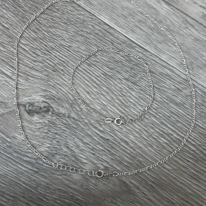 Silverhalsband och armband GHA 925 - Säljer ett matchande set med halsband och armband i äkta silver från GHA, båda märkta med 925. Kedjorna har en tunn, klassisk design med små länkar och smidiga ringlås. Perfekt för dig som gillar stilrena och tidlösa smycken i silver. Båda för 300