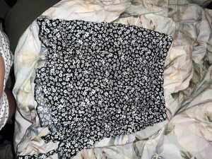 Svartvit blommig kjol - Supersöt svart kortkjol från New Look med vitt blommönster. Kjolen har knytband i sidan och är gjord i ett lätt och skönt material.