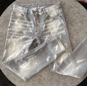 Dsquared2 jeans grå - Snygga grå jeans från Dsquared2 med coolt blekt och slitet mönster. Klassisk femficksmodell med Dsquared2-logga på bakfickan och röd etikett vid gylfen. Raka ben och normal passform.