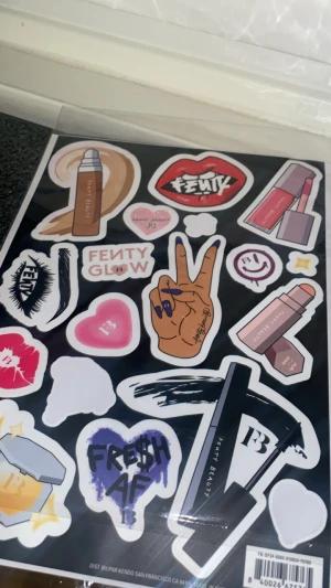 Fenty Beauty sminkstickers - Stickerark med Fenty Beauty-motiv som visar sminkprodukter som foundation, highlighter, läppglans och mascara. Färgglada och snygga stickers med motiv i beige, rosa, lila och svart, perfekt för att dekorera din sminkväska eller laptop använd två gånger bara 