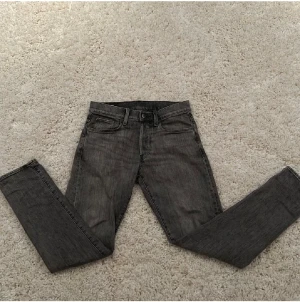 Grå G-star jeans slim fit - Säljer ett par gråa G-star jeans med snygg tvätt och klassiska fem fickor. Jeansen har slim passform, raka ben och svart patch bak i midjan. Materialet är robust denim i bomull och de har diskreta detaljer på bakfickorna. Storleken är W28/L32. nypris på dessa ligger på runt 1500kr och mitt pris 499kr!