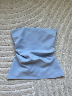 Ljusblå tubtopp från Zara - Säljer en ljusblå tubtopp från Zara i storlek S med dragkedja där bak.