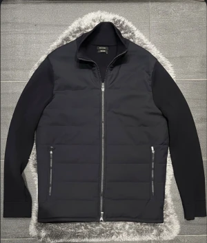 Massimo Dutti Cardigan Hybrid Jacka Svart - Massimo Dutti svart cardigan/hybridjacka i storlek M. Mycket fint skick och fungerar både som mellanlager och lätt jacka. En liten lagning vid nacken finns men den syns knappt och påverkar inte användningen. Snygg, stilren och i hög kvalitet. 