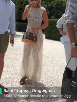 Lång vit spetsklänning med blommönster - Säljer en superfin långklänning i vit spets med blommigt mönster. Klänningen är ärmlös och har en kroppsnära passform som ger en elegant siluett. Perfekt för sommarens alla tillfällen när du vill känna dig extra chic.