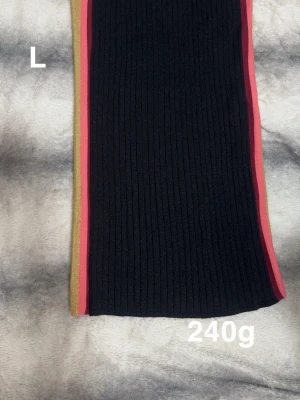 Svart ribbad kjol med ränder - Säljer en svart ribbad kjol med snygga vertikala ränder i guld och rött längs sidorna. Kjolen har en elastisk midja och är figurnära med en sportig känsla. Perfekt för dig som gillar färgdetaljer och vill sticka ut lite extra.🌸Fint använt skick. Glittertyg. Storlek L 