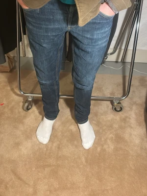 Dondup mörkblå jeans slim fit -  Ett par mörkblå jeans från Dondup, modell:George. Jeansen har orange sömmar och en smal passform som sitter tight längs benen. Perfekt för den som gillar en stilren och modern look. Storlek 31,  Skick 9.5, nypris 4000kr, mitt pris 599kr. Hör av dig vid funderingar 📩