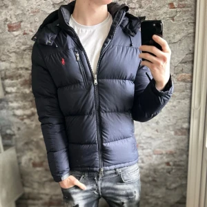 Ralph Lauren Gorham Jacka - Mycket fint skick, två små lagningar bara. Storlek 48/S passar dig som är mellan 175-185cm ungefär. Nypris ca 5000kr. Modellen är 185 cm, 79 kg. Självklart äkta - Kolla bara recensionerna! Passar bra nu till vintern. Skriv för mer information!🤝
