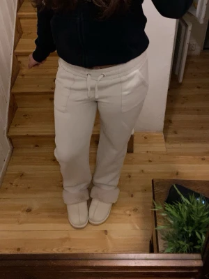 Vita mjukisbyxor med snörning - Säljer ett par vita mjukisbyxor med snörning i midjan och praktiska fickor. Byxorna har en avslappnad passform och är perfekta för chill dagar. Materialet är mjukt och skönt, och midjan är hög för extra komfort.