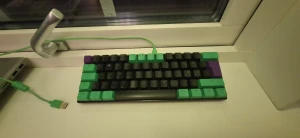 NOS C450 Mini Keyboard Pro Riddle - NOS C450 Mini Keyboard Pro Riddle med RGB-belysning och unika gröna, svarta och lila tangenter. Kompakt design, nordisk layout och USB-anslutning. Tangenter och hölje i fint skick, inga synliga defekter. Perfekt för gaming eller arbete där platsbesparing är viktigt och den är 60%.