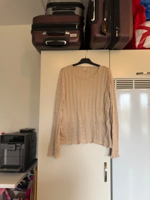 Beige stickad långärmad tröja A&A - Säljer en beige stickad tröja med snyggt kabelstickat mönster och rund hals. Tröjan har långa ärmar och vågig kant vid halsen, vilket ger en extra detalj. Perfekt för dig som gillar mjuka och mysiga plagg med lite vintagekänsla. Från märket Odd Molly. Storlek 3 som enligt deras storleksguide motsvarar en L. Den ör mer använd men har en del kvar att ge. Finns små tecken på användning. 