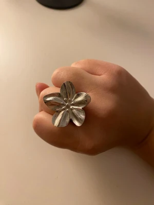 Stor silverfärgad blomring - Säljer en skitsnygg ring ifrån shien. Aldrig använd och helt ny! Silver! Kan töja ut så att den passar just ditt finger. Skriv för frågor eller annat💝