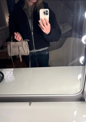 Svart teddyjacka från Weekday - Svart teddyjacka från Weekday med passform dragkedja framtill. Jackan har fluffig textur och långa ärmar. Perfekt för dig som vill ha en mysig och trendig look under höst och vinter.