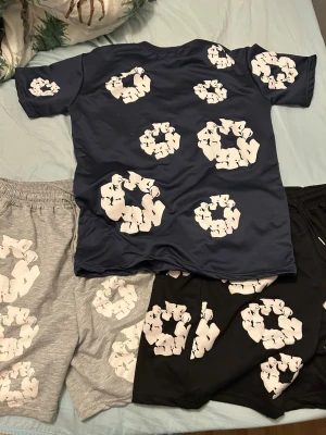 Grå och svarta shorts med vit print - Säljer två par shorts, ett par grå och ett par svarta, båda med elastisk midja  