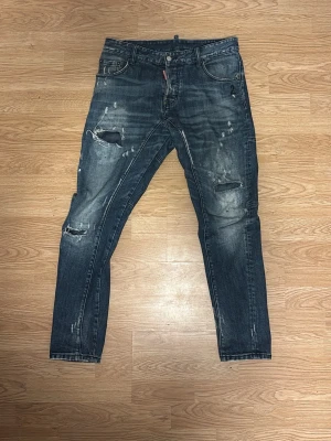 Mörkblå Dsquared2 jeans - Snygga mörkblå Dsquared2 jeans. Skinny fit med klassisk femficksdesign och dragkedjegylf. Jeansen har en cool, tvättad look och detaljerade sömmar över benen. Perfekta för en avslappnad streetstil.