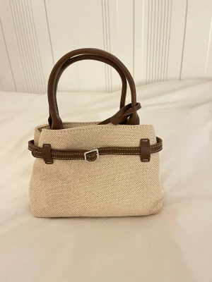 Zara handväska vit, biege brun axelband - Jättefin oanvänd väska från Zara. Axelband följer med.🤩 Nypris 499kr